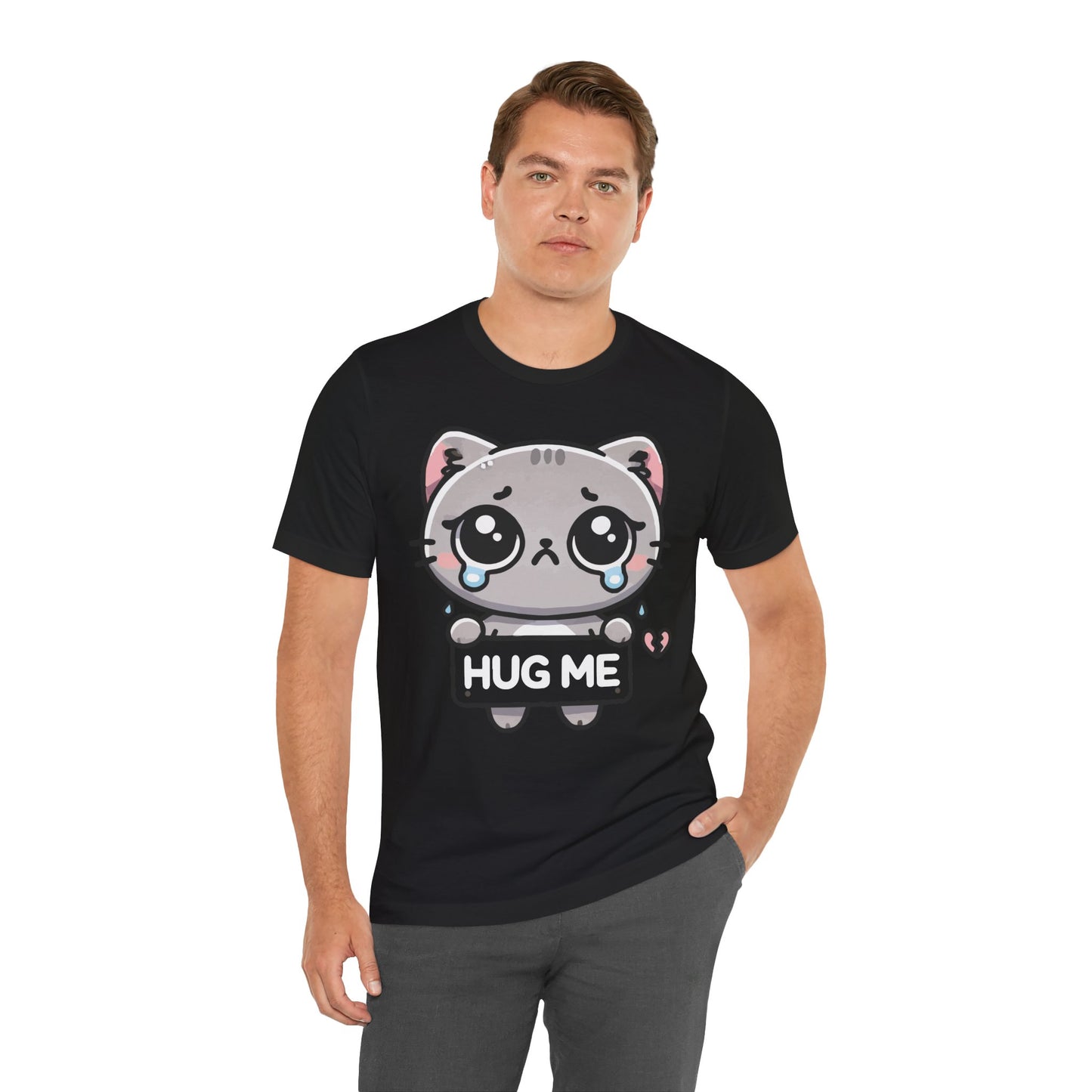 Black t-shirt with a cute sad grey cartoon cat holding a “Hug Me” sign, teary-eyed with a small broken heart graphic near its paw.