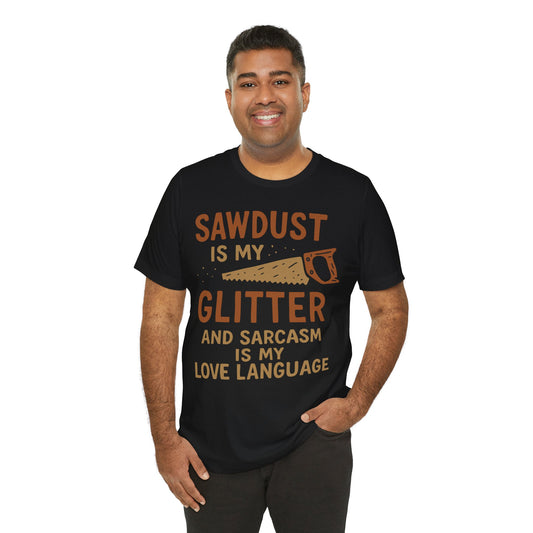 Black t-shirt featuring a humorous quote "Sawdust is my glitter and sarcasm is my love language" with an illustrated hand saw in a rustic design.