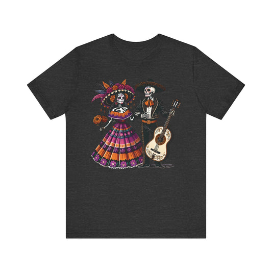 Black heather t-shirt featuring a vibrant Day of the Dead skeleton couple, with the female skeleton in a colorful traditional Mexican dress and hat, and the male skeleton wearing a mariachi suit and sombrero, holding a guitar.

