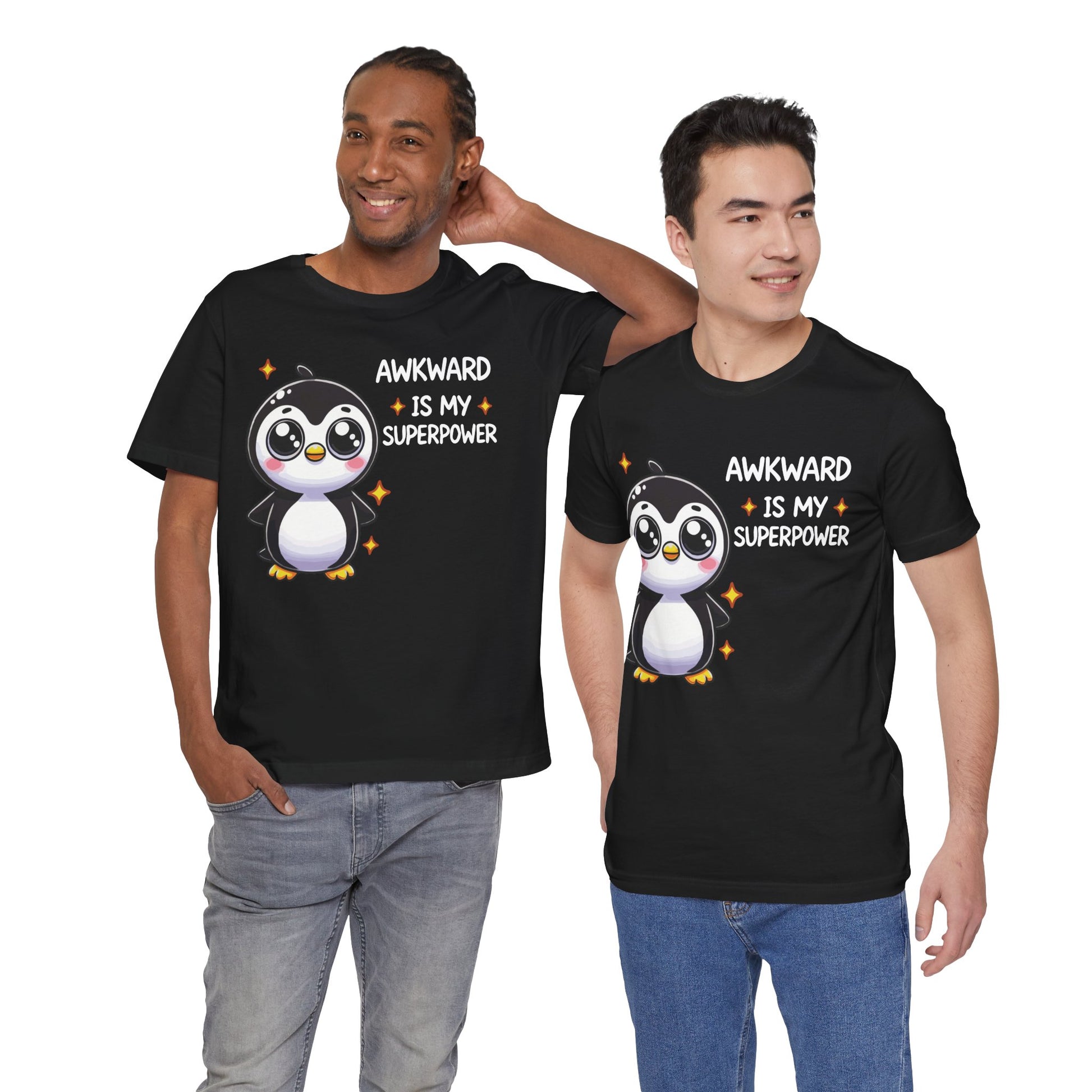 Two people wearing black t-shirts featuring a cute cartoon penguin with sparkles and the phrase "Awkward Is My Superpower" in playful white and orange text.

