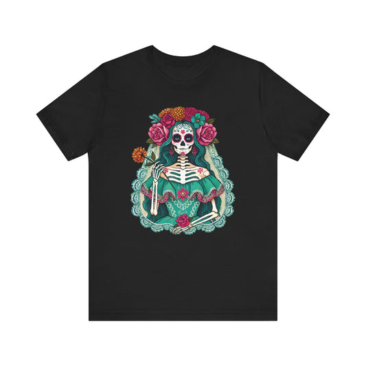 Black t-shirt featuring an ornate portrait of an elegant skeleton lady (La Catrina) with teal dress, red and orange flowers, lace border, and sugar skull makeup in Día de los Muertos style.

