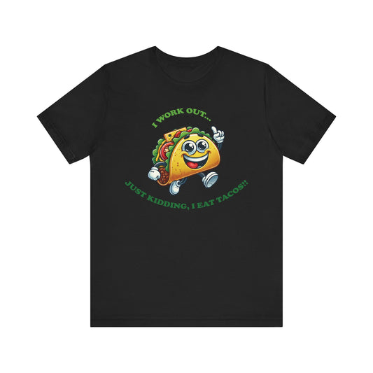 Black t-shirt with a cute cartoon taco wearing running shoes and smiling, surrounded by the funny text "I WORK OUT... JUST KIDDING, I EAT TACOS!!" in green lettering.

